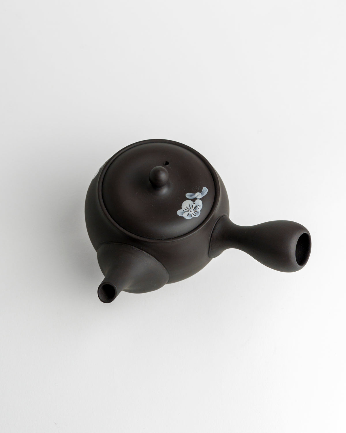 Schwarze Teekanne mit weißen Blüten