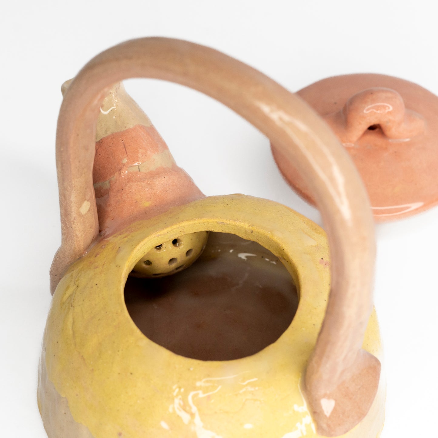 Pink and yellow coloured clay teapot