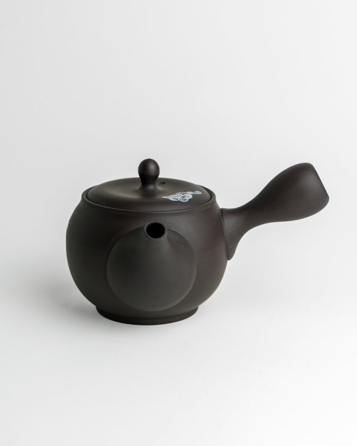 Schwarze Teekanne mit weißen Blüten